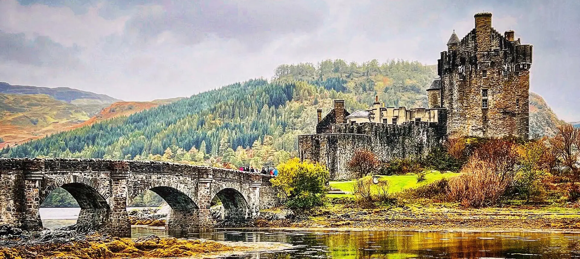 A bridge over water near a castle.